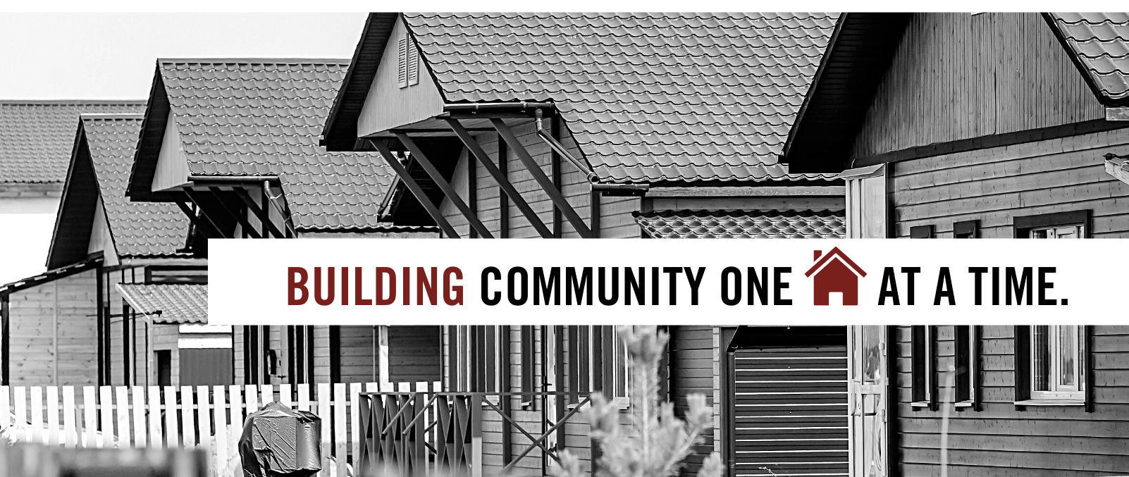 Building community one home at a time. Text on Black and white homes background.